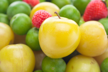 Fototapeta na wymiar background of strawberry, green and yellow plum