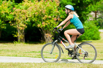 Obraz premium Young smiling woman on bike