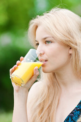 Smiling woman drinking orange juice