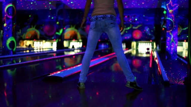 girl throws bowling ball and unusual way and misses aim in club
