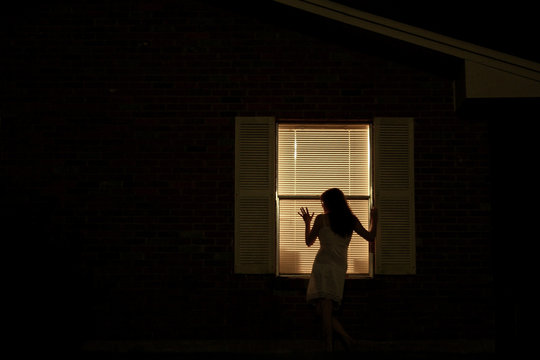 Woman at Window at Night