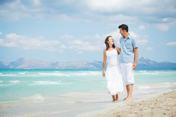 Fototapeta na wymiar Happy young couple walking on beach