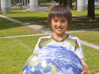 地球の形をしたボールを持つ少年