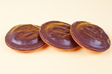 Three chocolate cookies yellow background