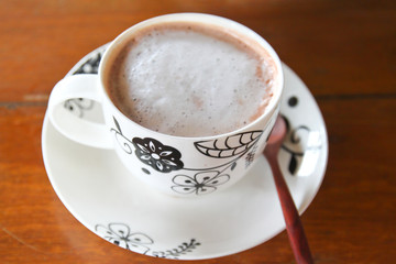 Cup of hot cocoa with wooden spoon