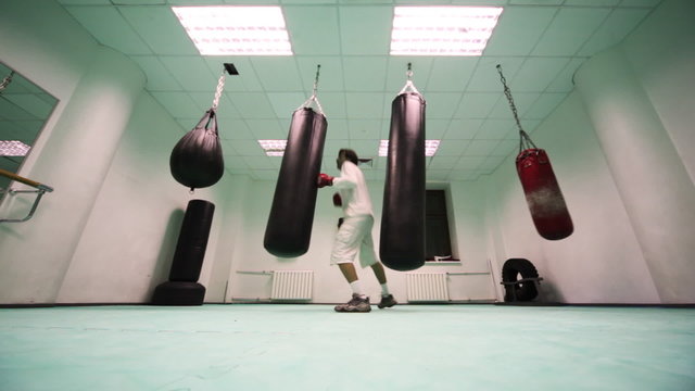 man  jumps and punches on punching bag at boxing gym, part4