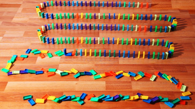 many colored dominoes built zigzag on parquet