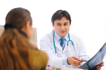 Obraz premium Smiling medical doctor showing roentgen to patient