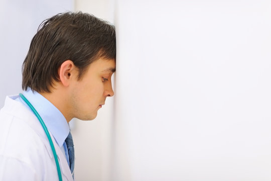 Tired Medical Doctor Leaned His Head Into A Wall