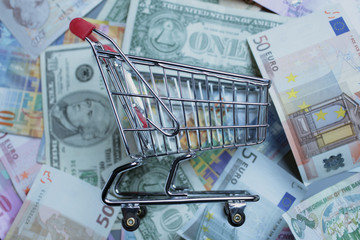 Einkaufswagen mit Banknoten Euro, Dollar, Franken, Pfund