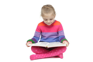 Little girl sitting on the floor reading the book