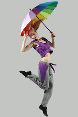 Young and beautiful female jumping high with umbrella