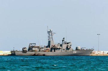 Big battle ship in the dock against blue sky and mountains