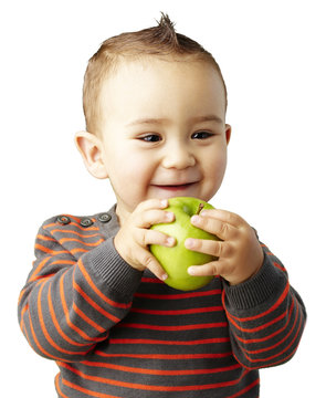 portrait of funny kid holding green apple and smiling over white
