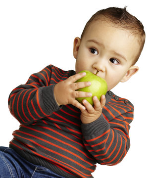 portrait of a handsome kid bitting a green apple over white back