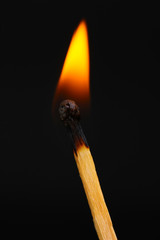 Burning match on black background