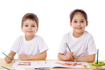 Two little kids draw with watercolor