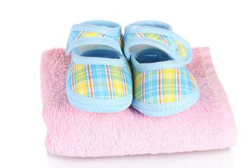 Blue baby booties on pink towel isolated on white