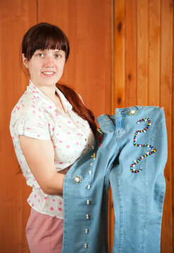 Woman shows   jeans beaded by herself