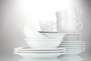 empty bowls, plates and cups on gray background