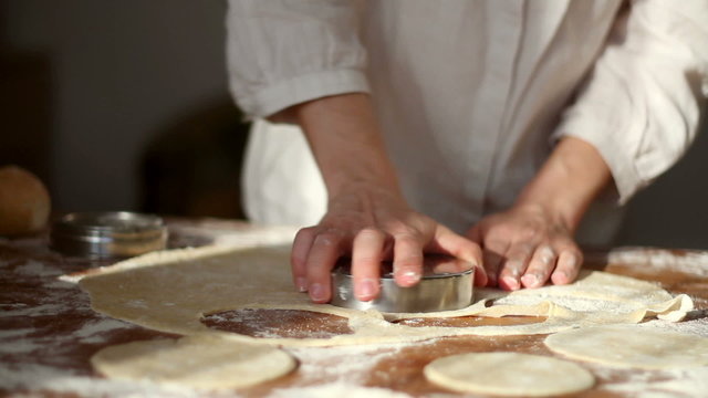 Baker cutting dough with cookie form