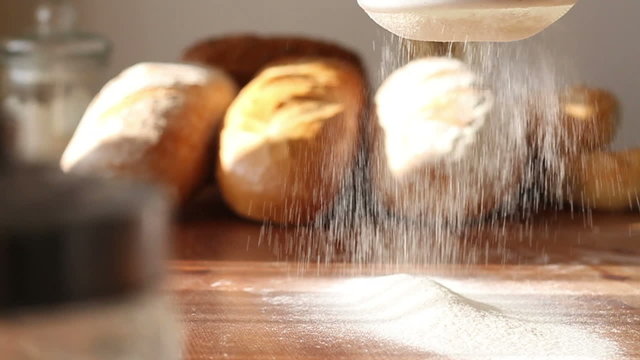 Hand sifts the flour through a sieve, slow motion, dolly shot