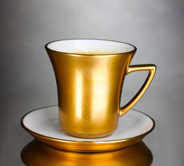 golden cup of coffee on gray background