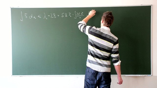 Boy is solving maths problems at the blackboard in fastmotion