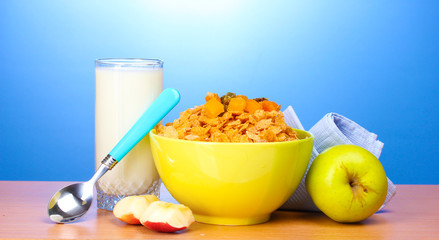 tasty cornflakes in green bowl, apples and glass of milk