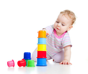Cute little boy building tower from colorful cups isolated on wh