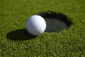 Golf ball at edge of hole