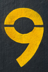 Number nine painted on black floor