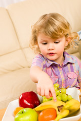 Fototapeta premium Little girl wants fruit pointing at banana