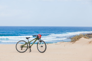 Fototapeta na wymiar Rower z kaskiem, stoją na plaży.