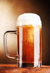 beer mug on wooden table on brown background