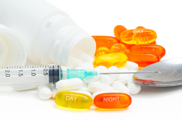 Pills, syringe, teaspoon and bottle. Aspirin day and night