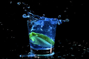 Éclaboussure de cocktail bleu dans un verre au citron