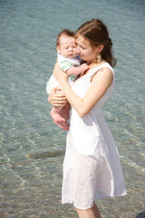 Fototapeta na wymiar loving mother and baby on water background