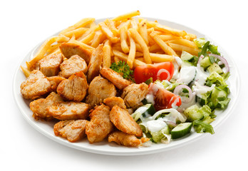 Grilled meat with French fries and vegetables