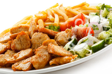 Grilled meat with French fries and vegetables