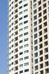 Fototapeta na wymiar Beige Stucco Condo Tower with Balconies on Blue