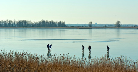 Men skating on a frozen lake
