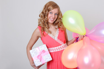 Happy woman with colourful balloons ang gift