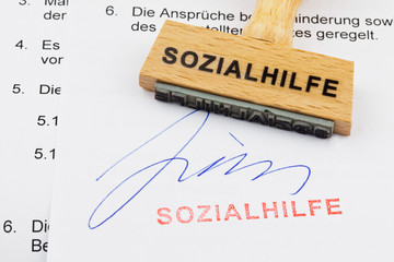 Holzstempel auf Dokument: Sozialhilfe