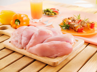 Fresh raw chicken breast arrangement on kitchen cutting board
