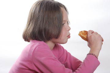 A  young girl eating a bun