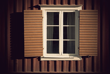 Vintage window with shutters on wooden wall