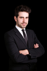 Handsome young business man standing on black background