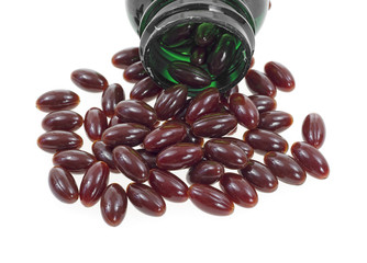 Cranberry supplements spilling out of vitamin bottle