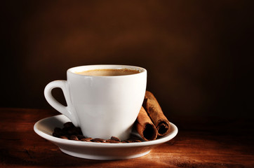 cup with coffee, cinnamon and coffee beans